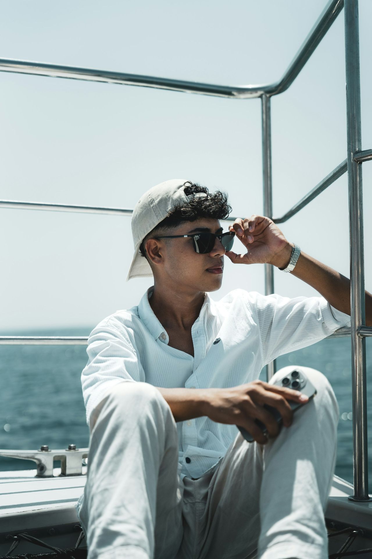 A man sitting on top of a boat next to the ocean